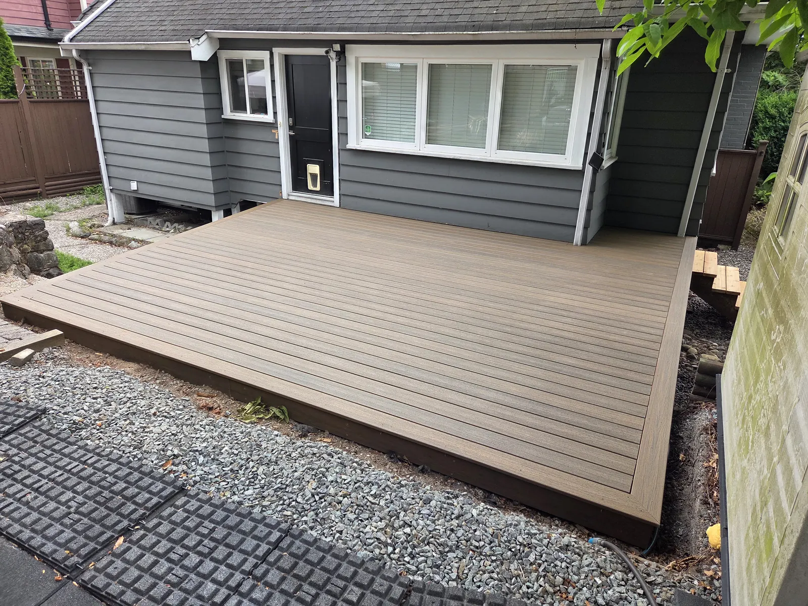 Newly built composite deck beside a grey house in New Westminster